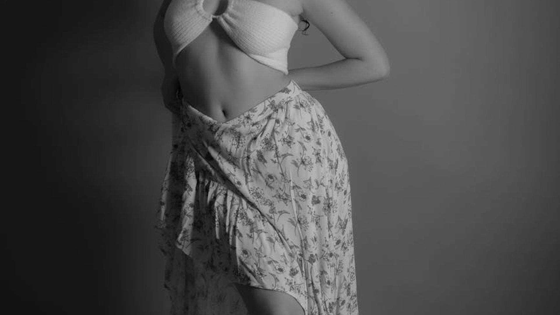 Person in a dynamic cardio movement pose in a minimalist studio.